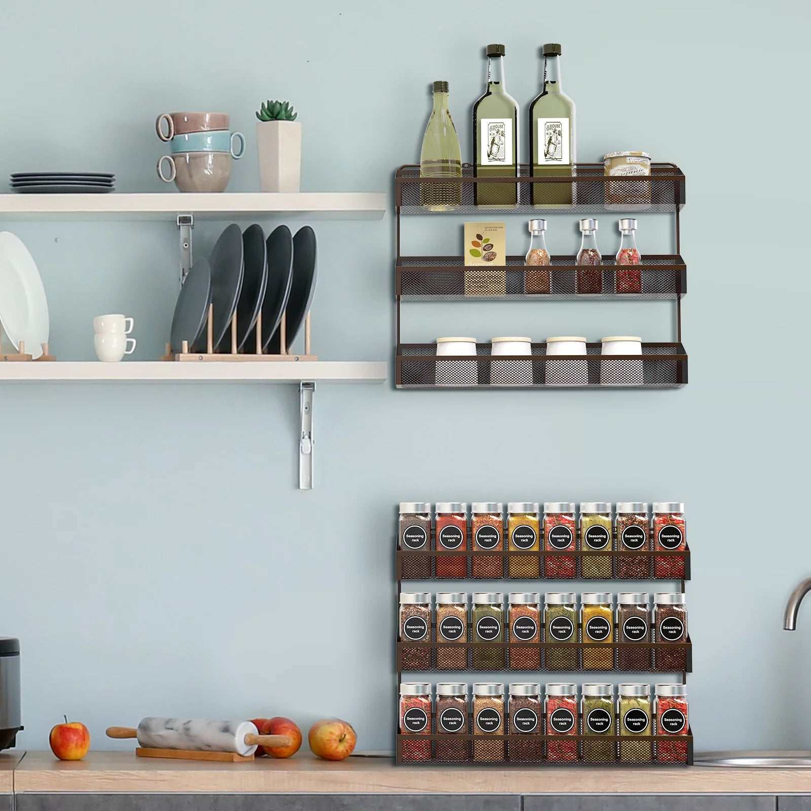 3 tier bronze spice rack organizer on kitchen wall with spice jars and bottles.